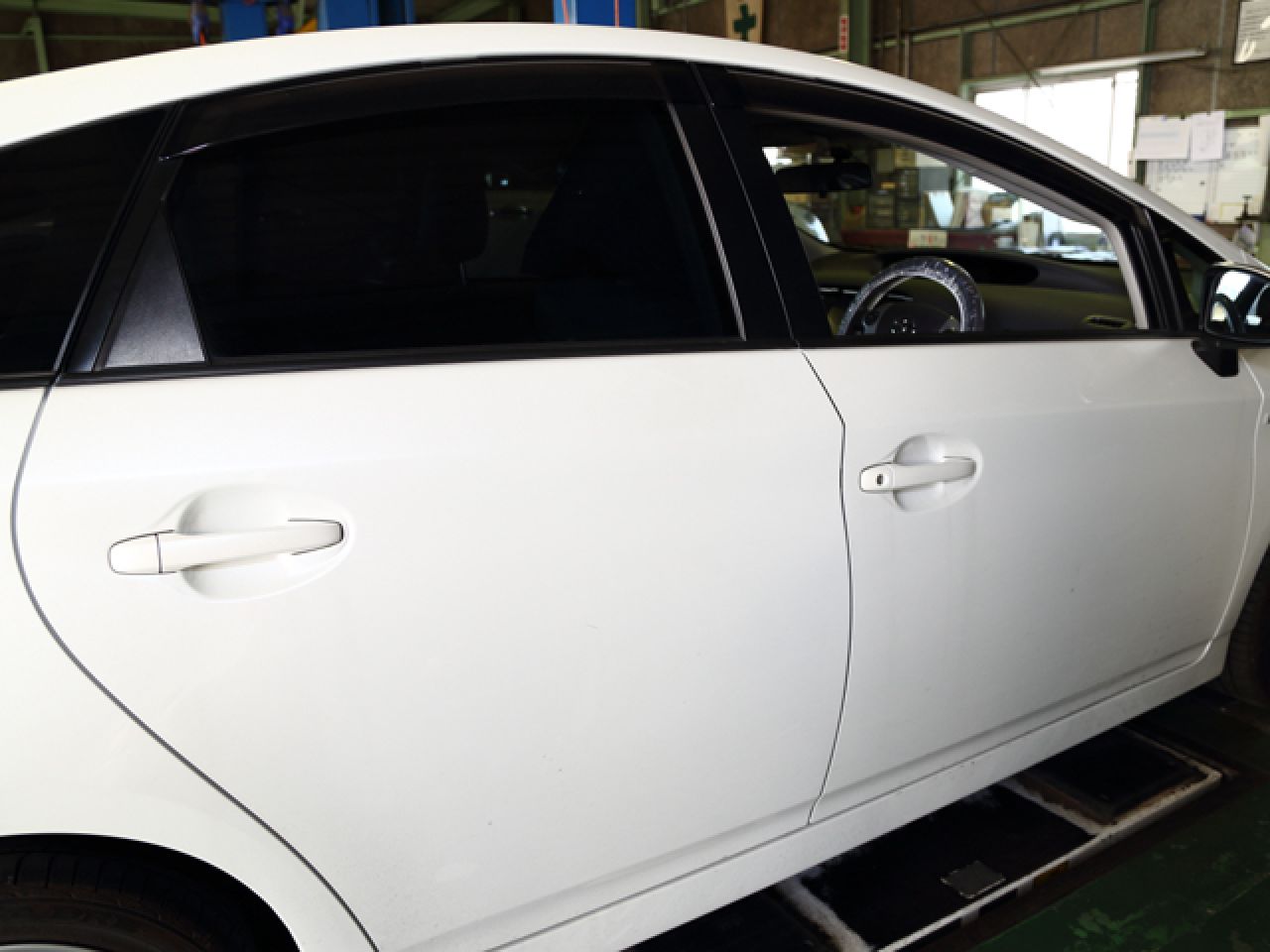 白い車の側面ドアと閉じられた窓ガラス